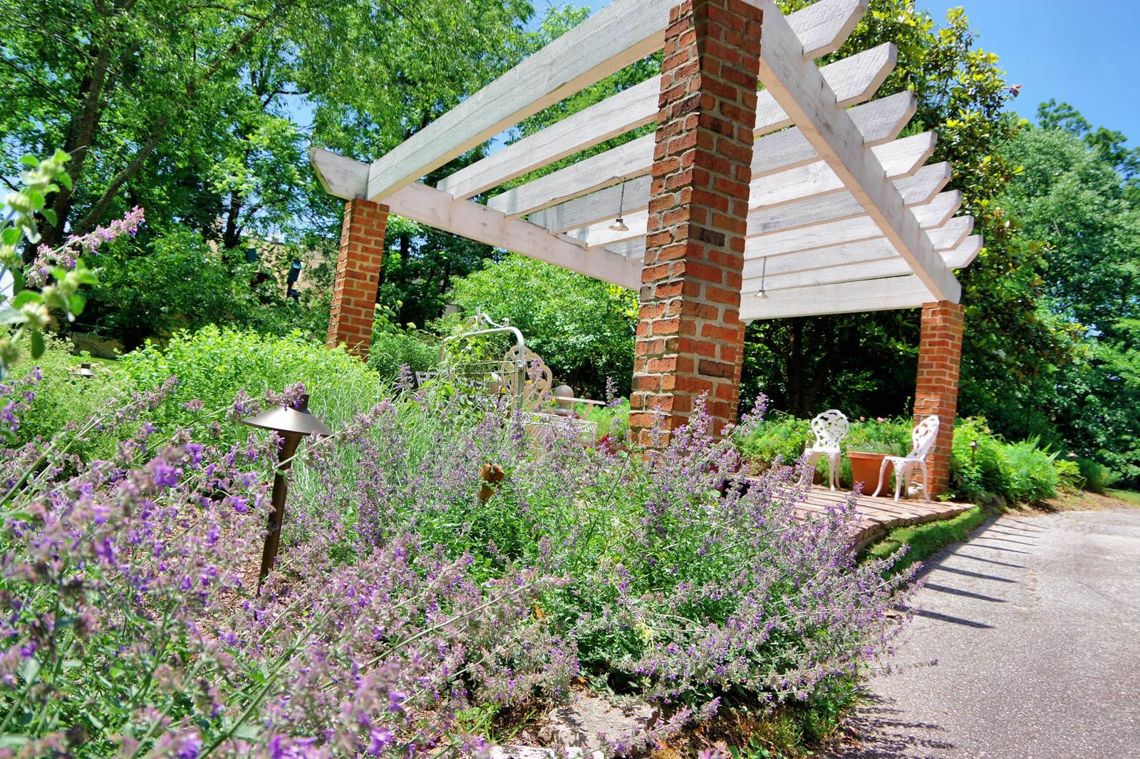 Garden pergola with brick pillars and flowering borders