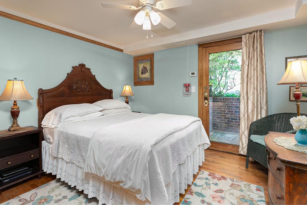 Terrace room with carved wooden headboard opening onto a private brick patio